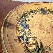 Vintage round ceramic plate with floral decoration.