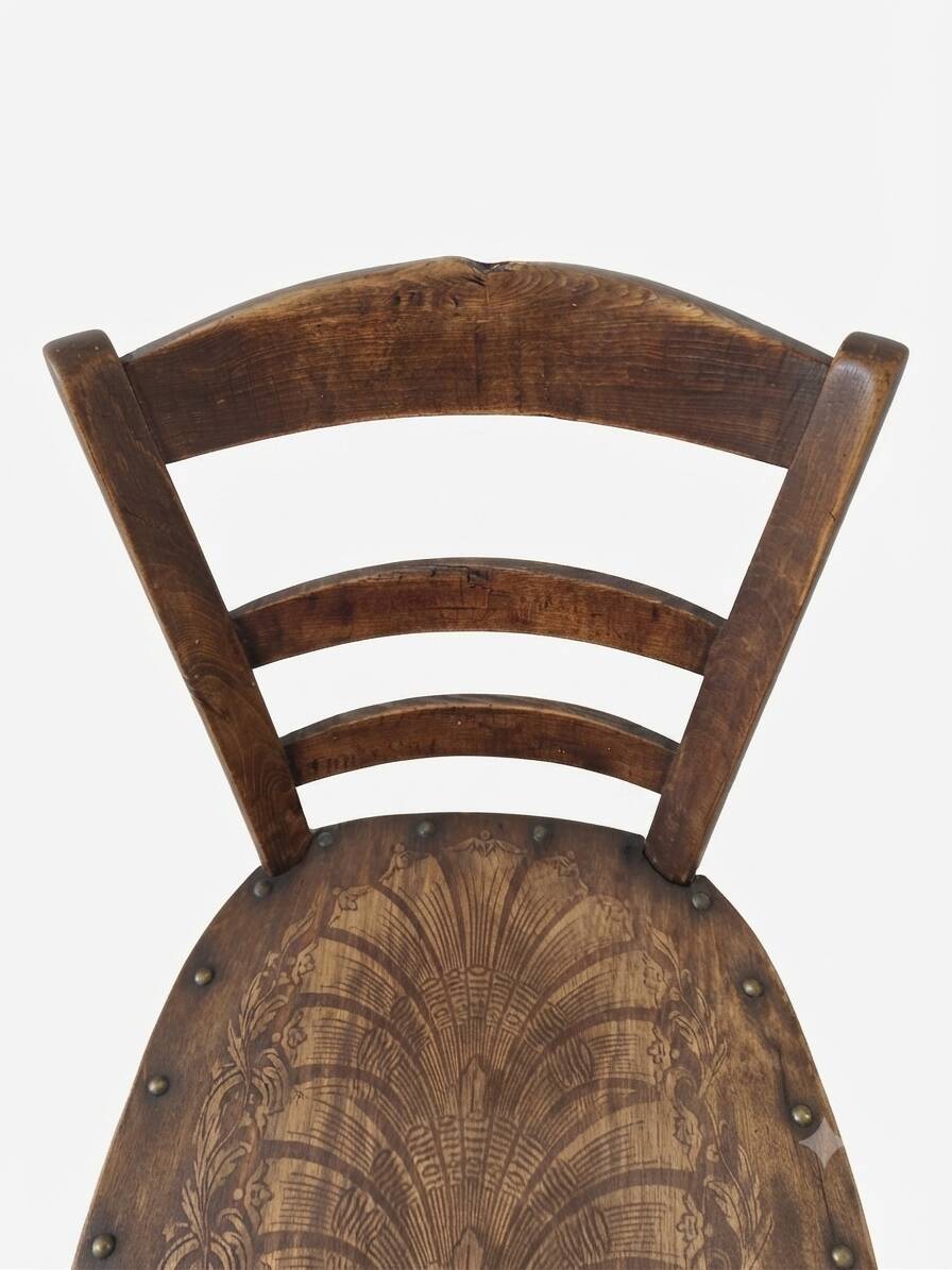 Antique wooden chair with a pyrographed shell motif seat.