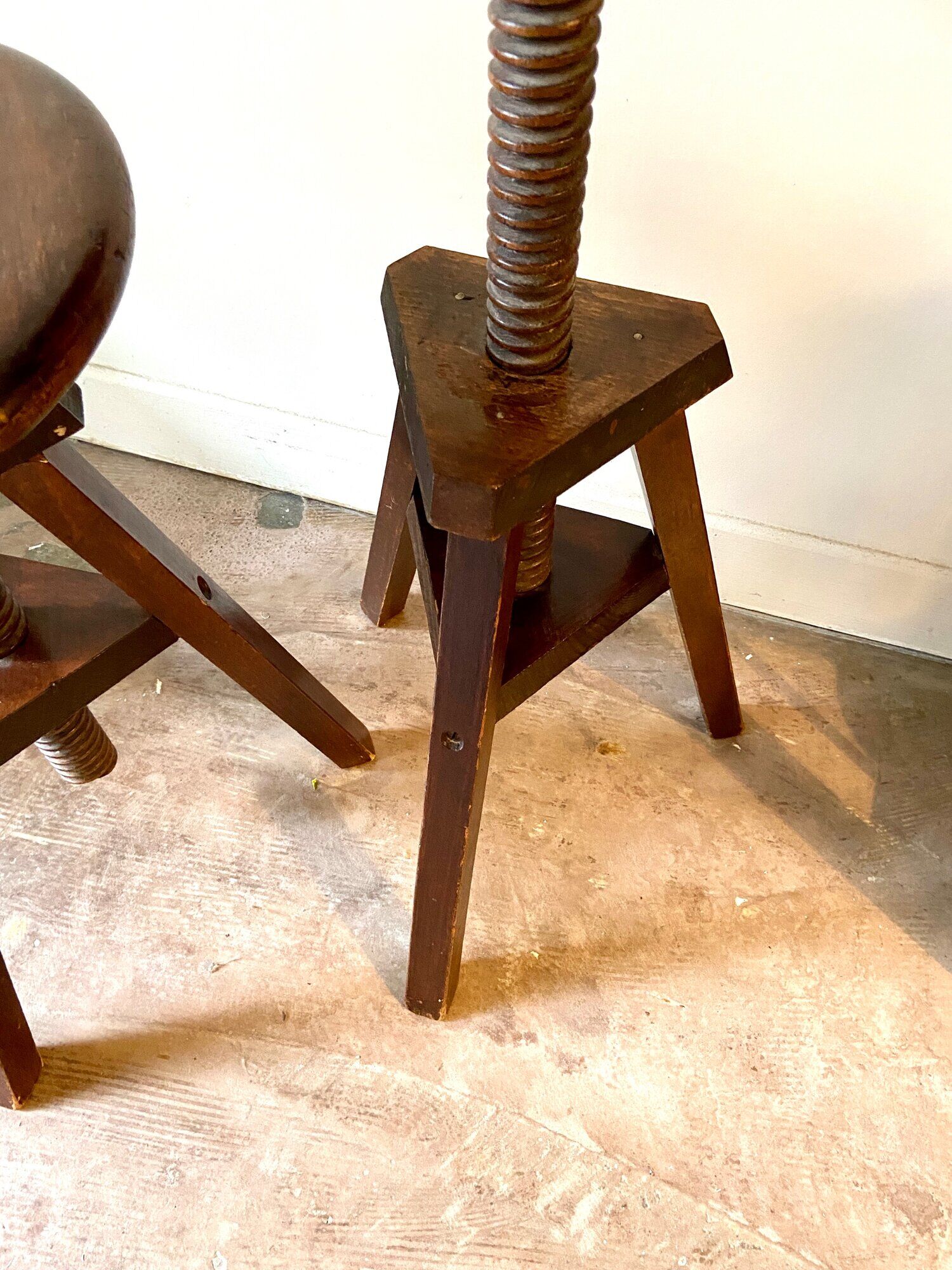 2 tripod stools with dark wood screws