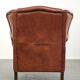 Light cognac-coloured cow leather wingback armchair with matching piping