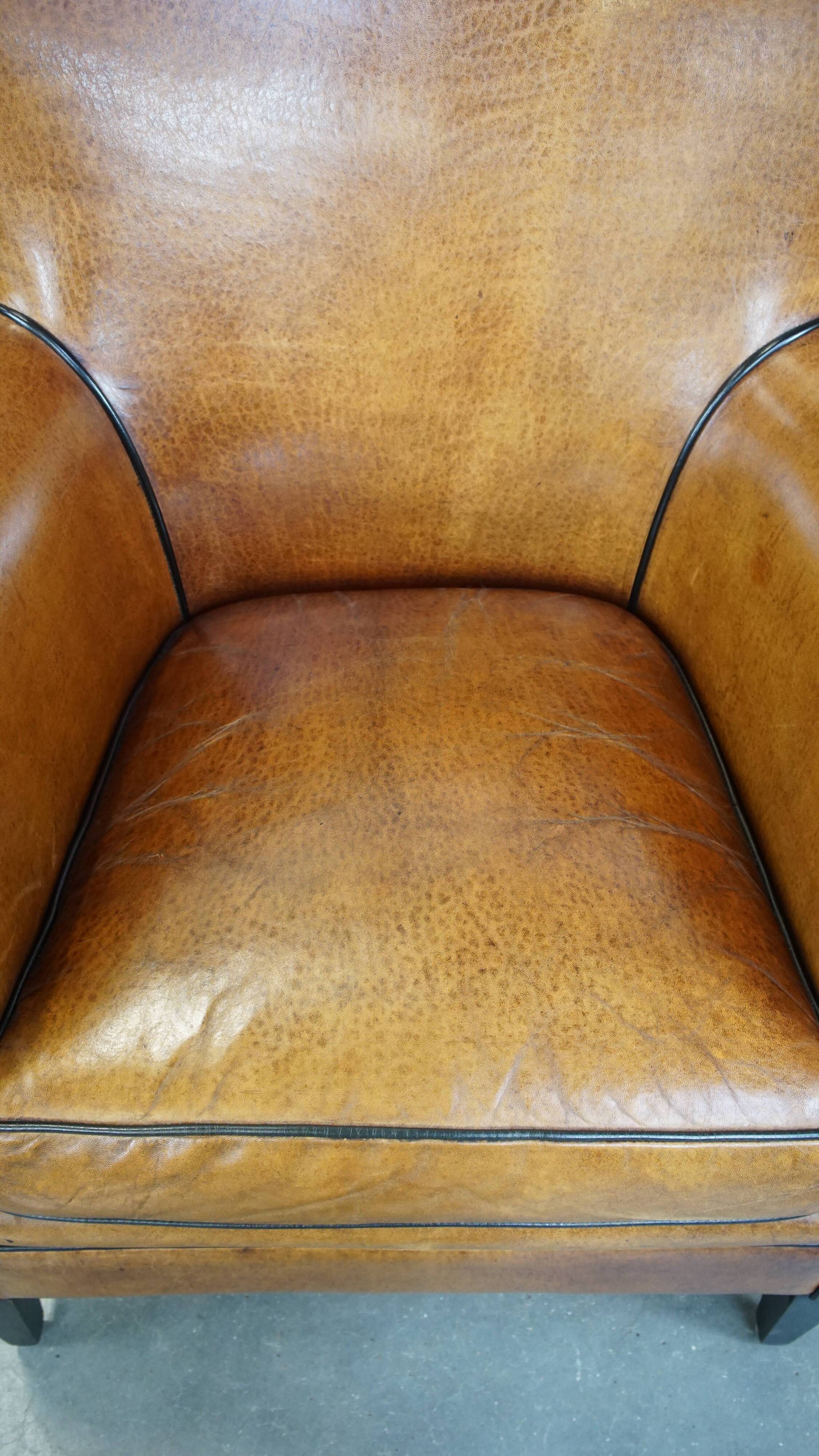 Cognac-colored sheep leather armchair finished with decorative nails