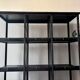 Black metal shelf with compartments.