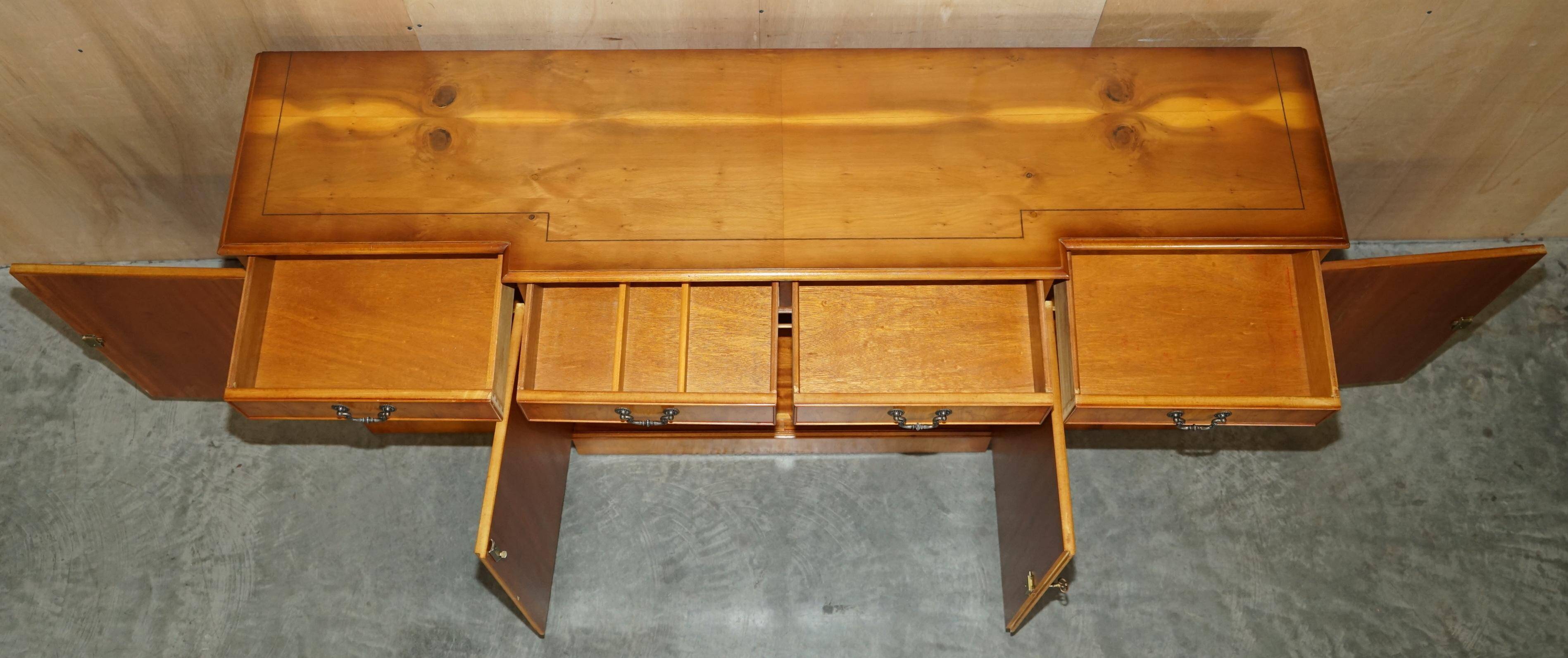 Vintage buffet made of mottled yew wood with three doors and four drawers.