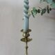 Brass candle holder with flowers and round shape.