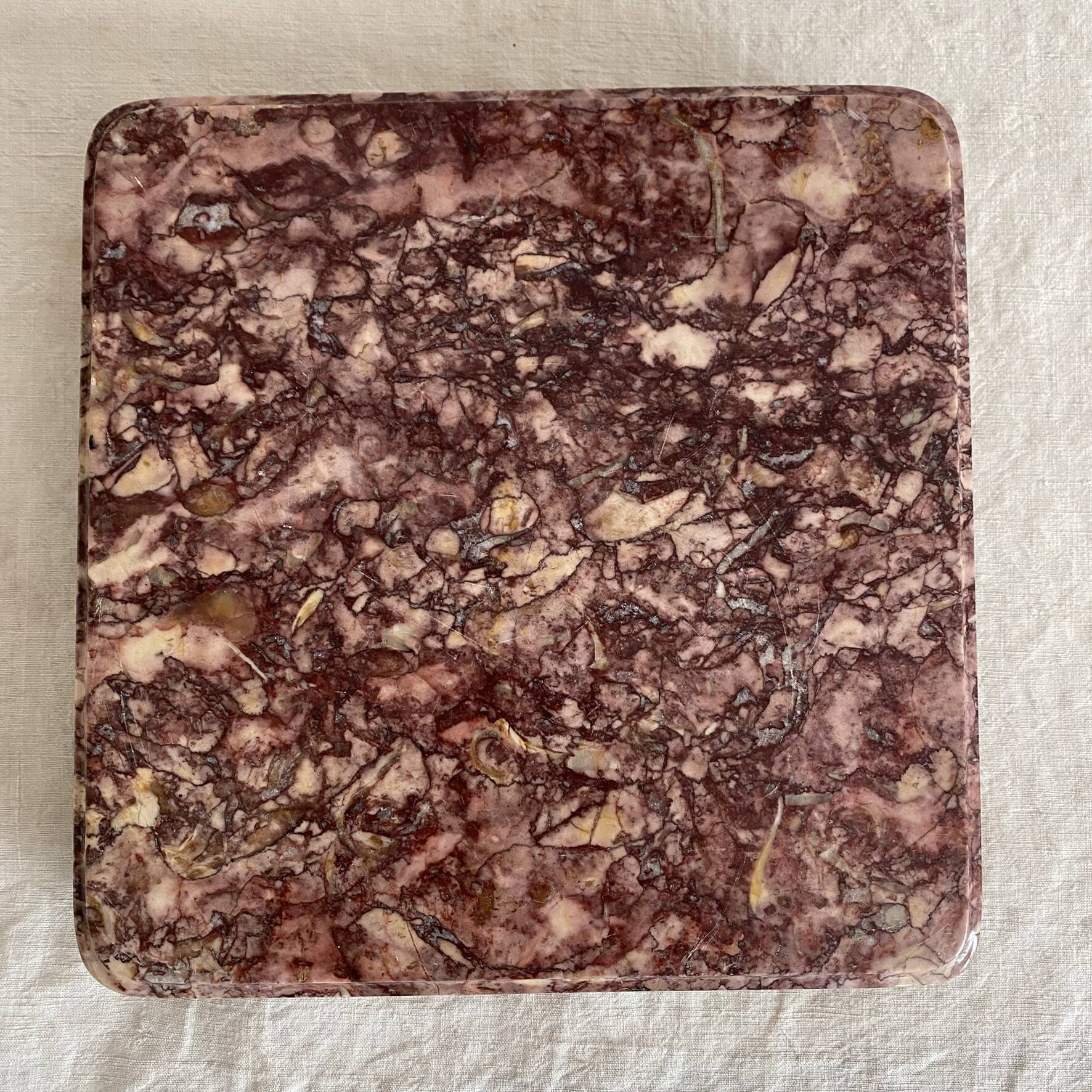 Pink marble trivet with brass ball feet.