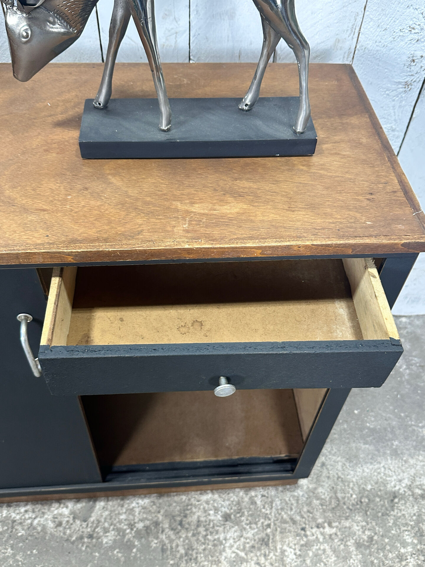 Small vintage black buffet with sliding doors.