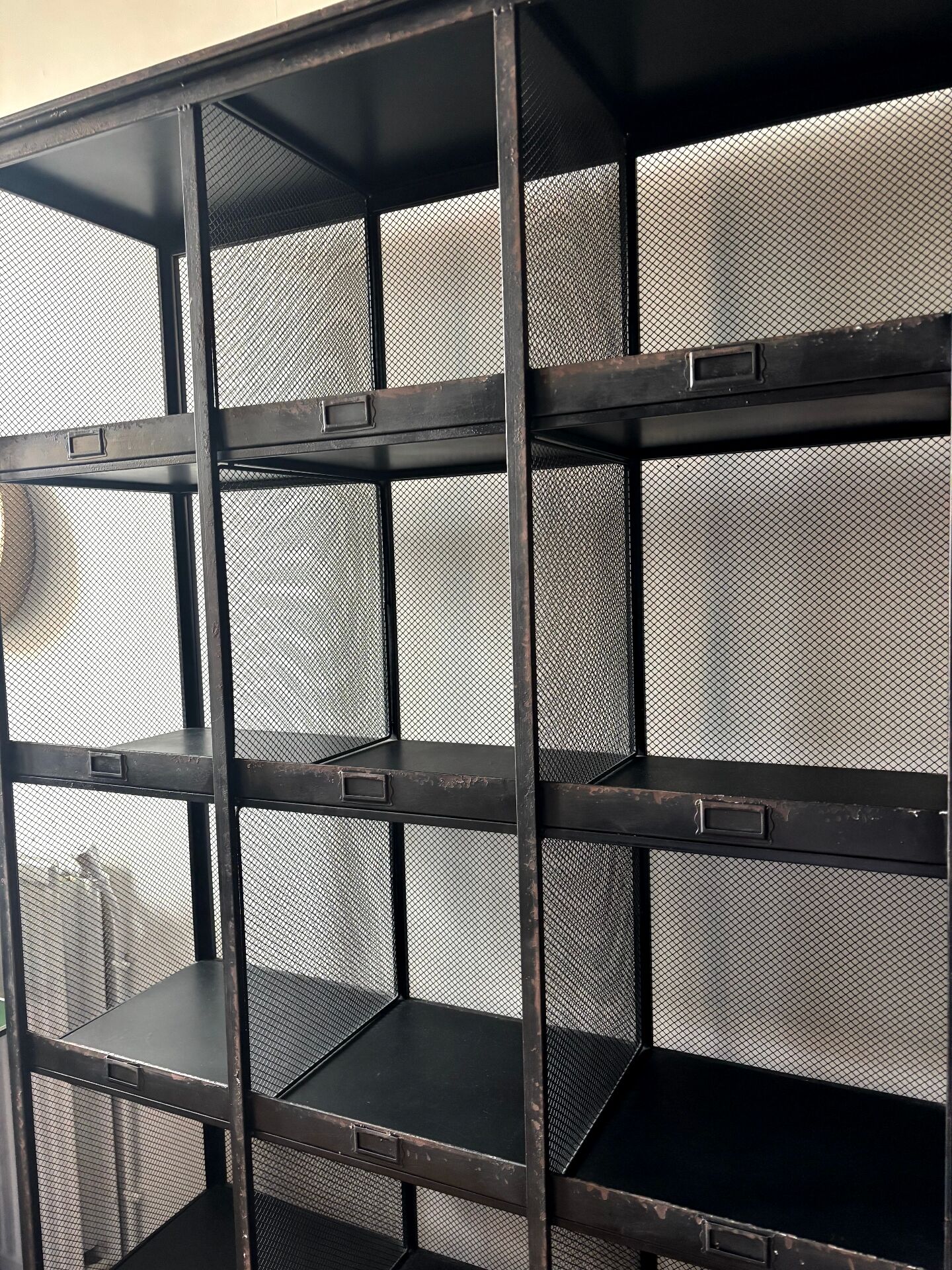 Black metal shelf with compartments.