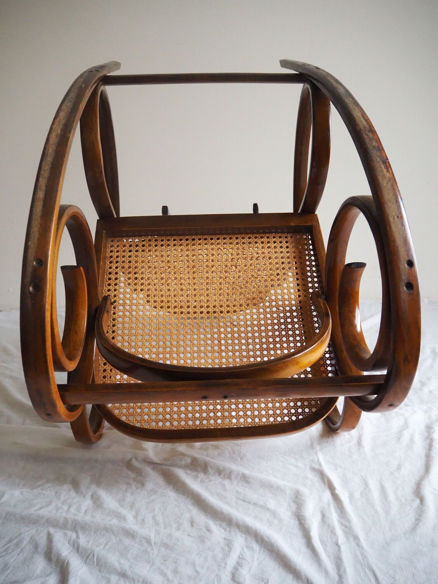 Rocking-chair en bois teinté et assise cannée