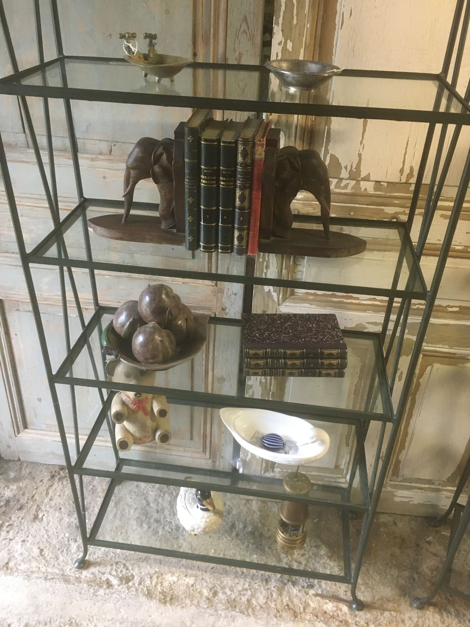 Pair of wrought iron and glass bookshelf shelves.