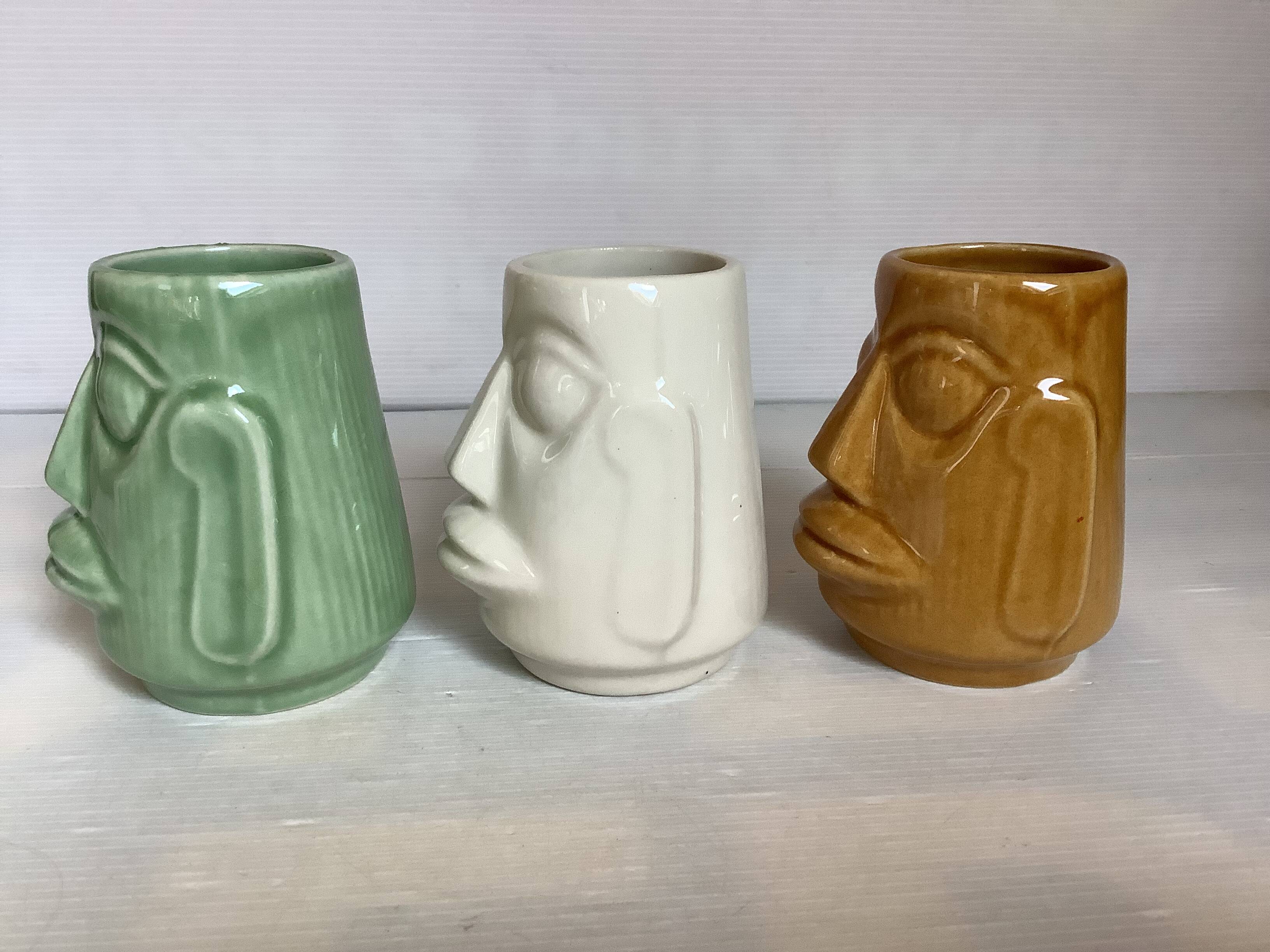 Set of three small Moai-style head vases.