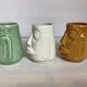 Set of three small Moai-style head vases.
