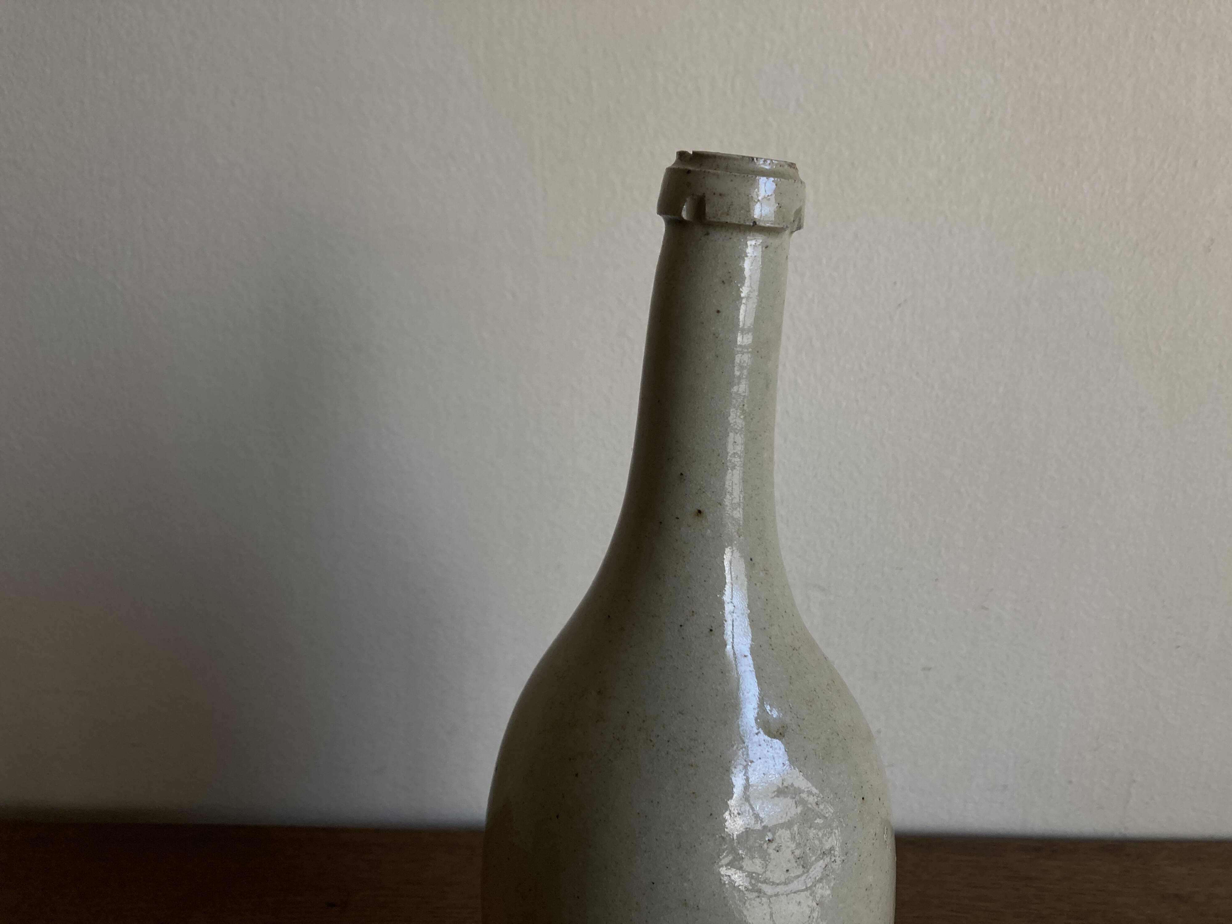 Stoneware bottle tilted at an angle, early 20th century