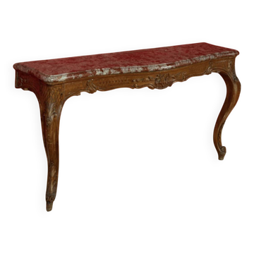 Important console in natural wood, moulded and carved with a red marble top.
