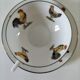 Cup and saucer in porcelain decorated with roosters and hens.