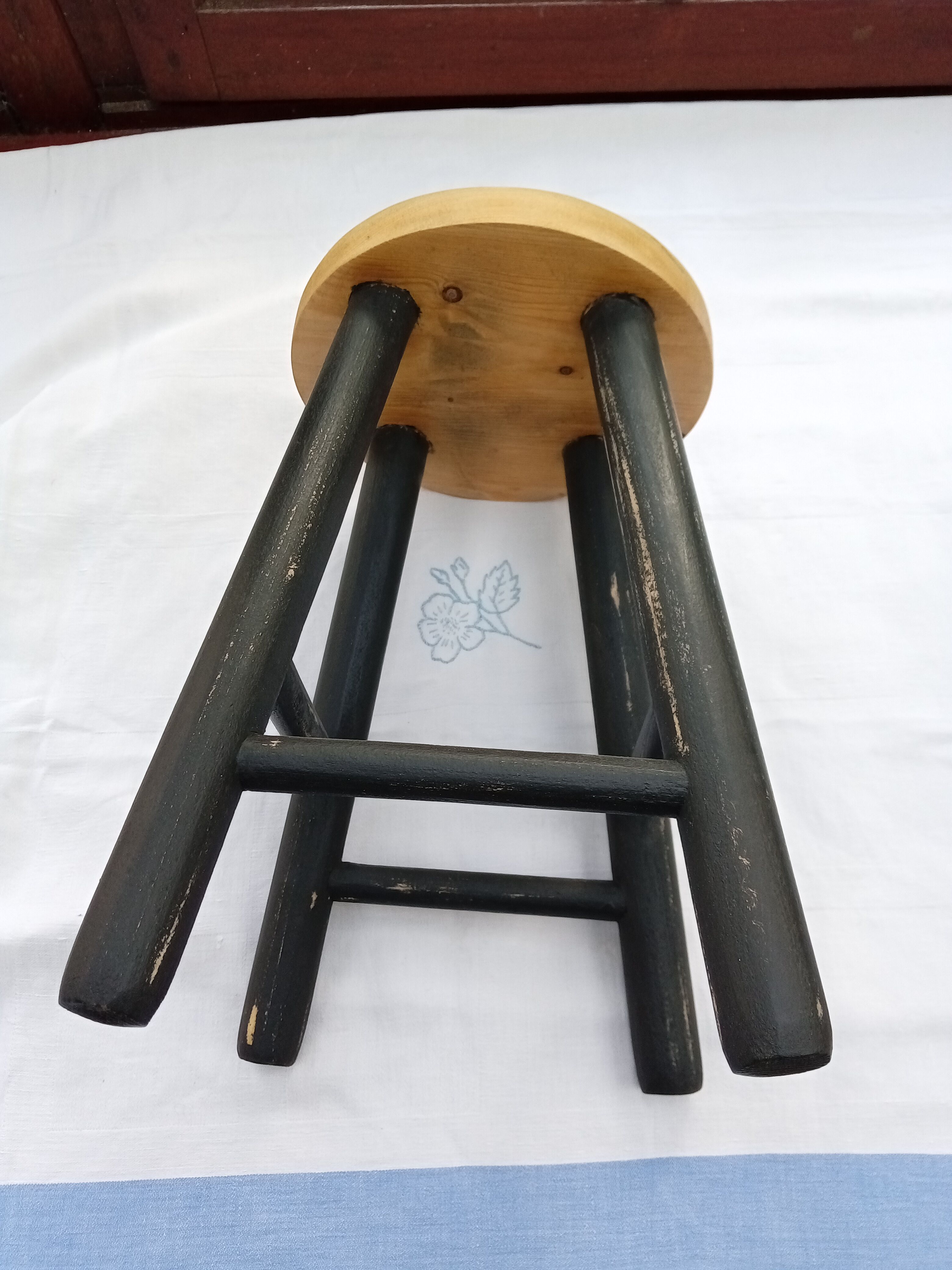 Low wooden stool and black patina