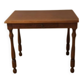 Table de style Louis-Philippe, en bois, avec tiroir et pieds tournés.