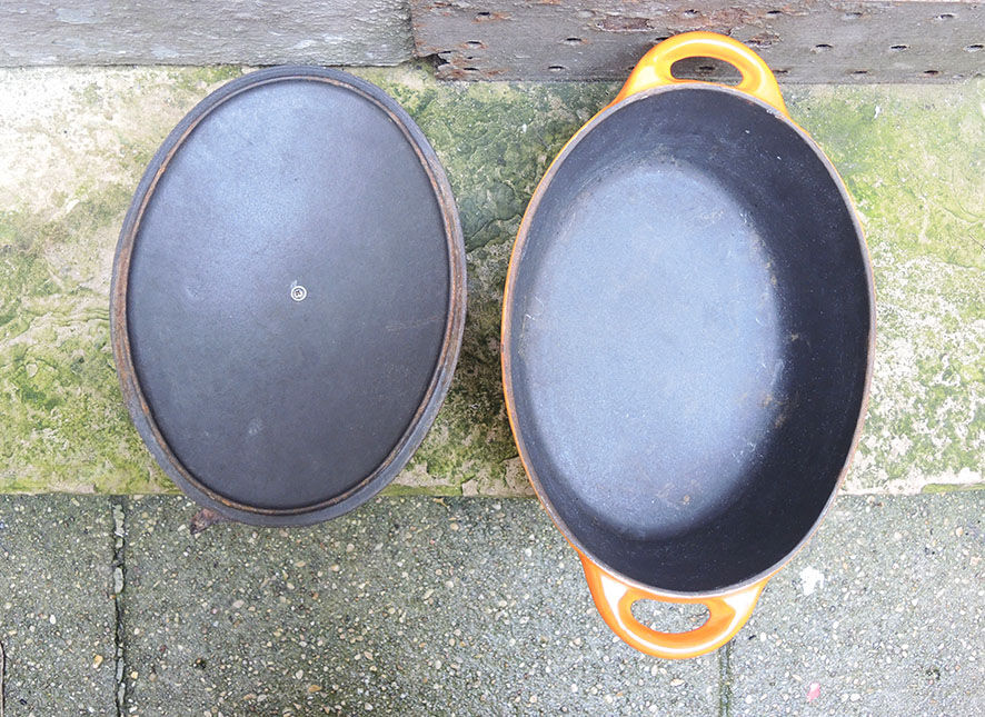 Old oval casserole in orange enamelled cast iron
