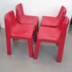 Four red fibreglass chairs from the 1970s.