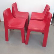 Four red fibreglass chairs from the 1970s.