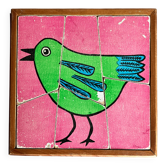 Wooden frame puzzle from the 1960s depicting a bird on a pink background.