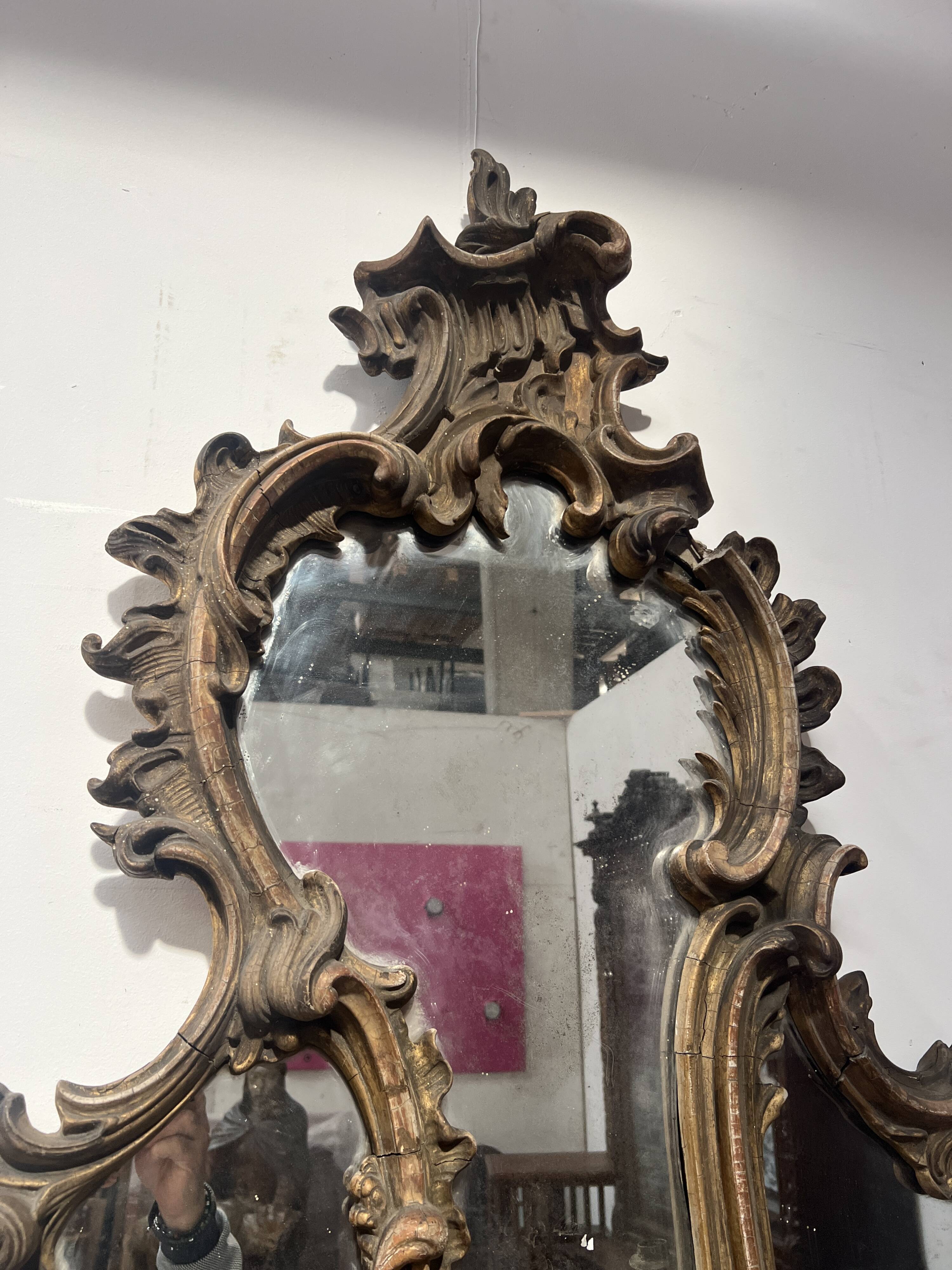 Mirror with a decorative frame featuring a four-light wall sconce, 19th century.