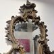 Mirror with a decorative frame featuring a four-light wall sconce, 19th century.