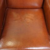 Correct, comfortable, luxurious English-style wingback armchair made of cognac-colored cow leather