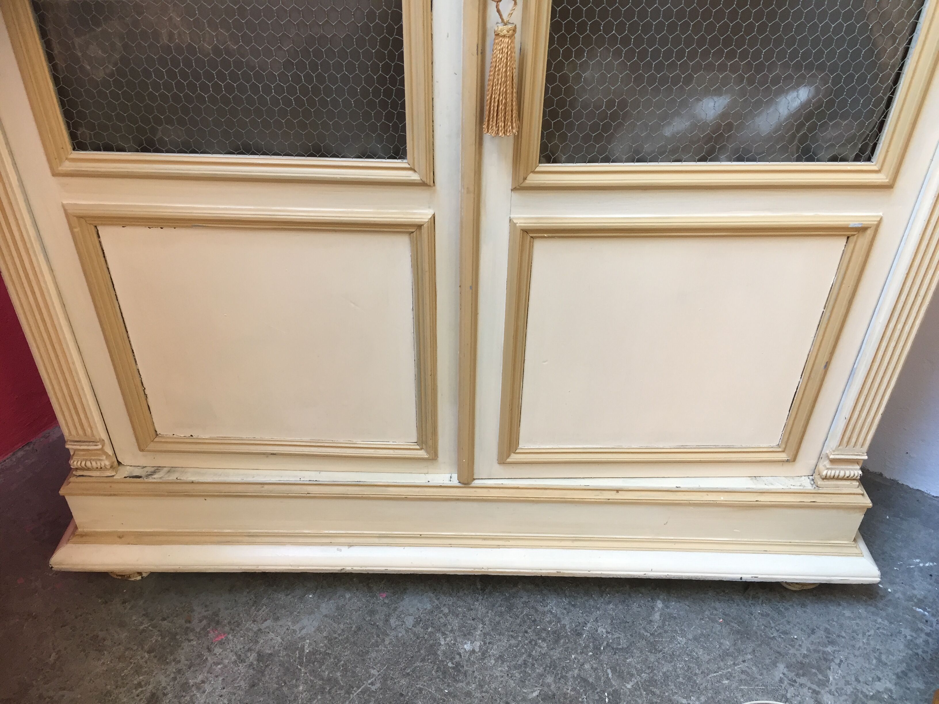 Bookcase 2 painted in ochre and cream mesh doors beginning 20 th