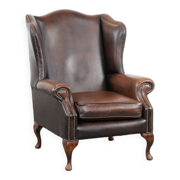 Chesterfield wingback armchair in smooth brown leather in the English style.