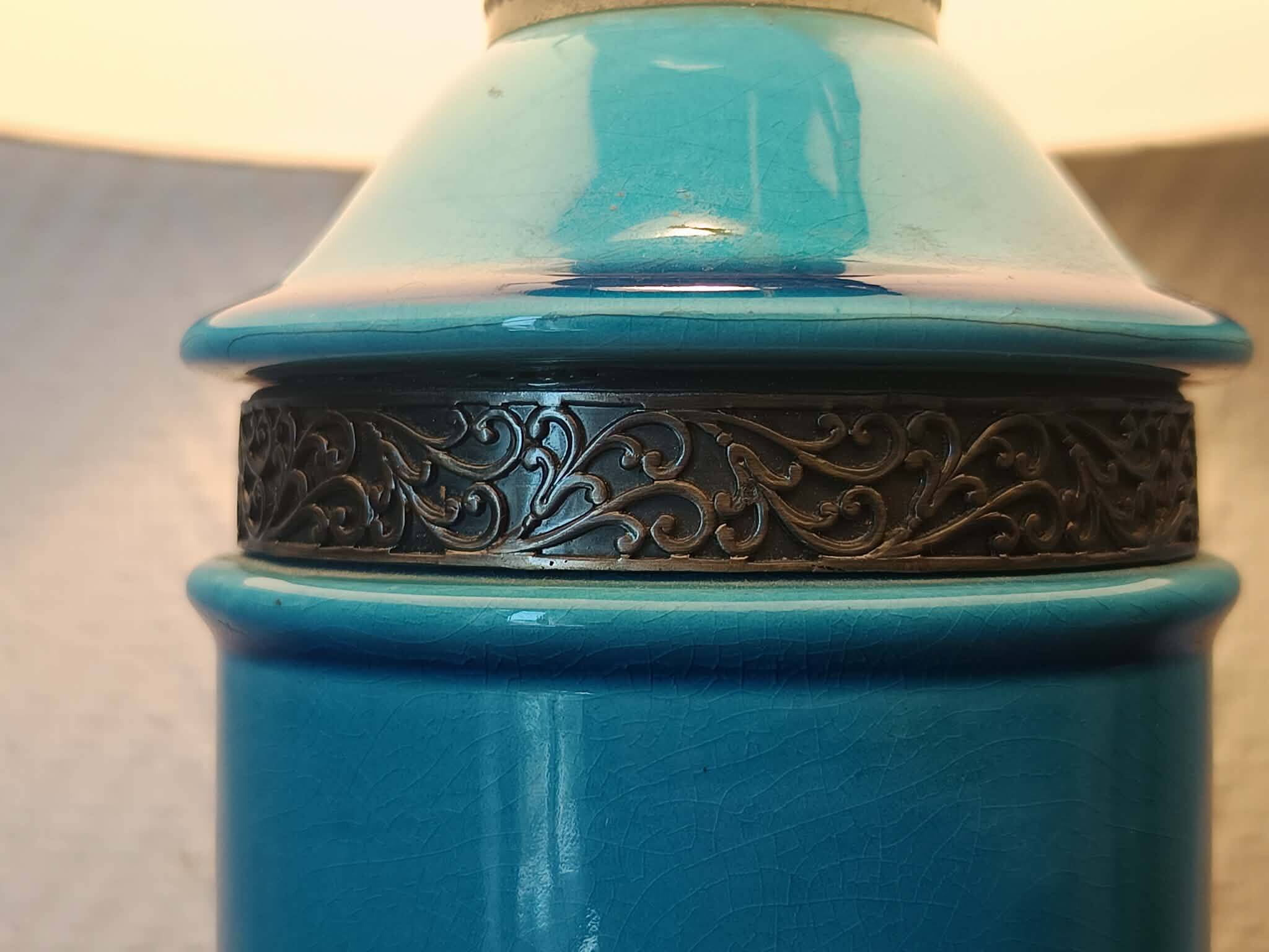 Blue ceramic lamp with claw feet and foliage lampshade.