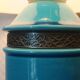 Blue ceramic lamp with claw feet and foliage lampshade.