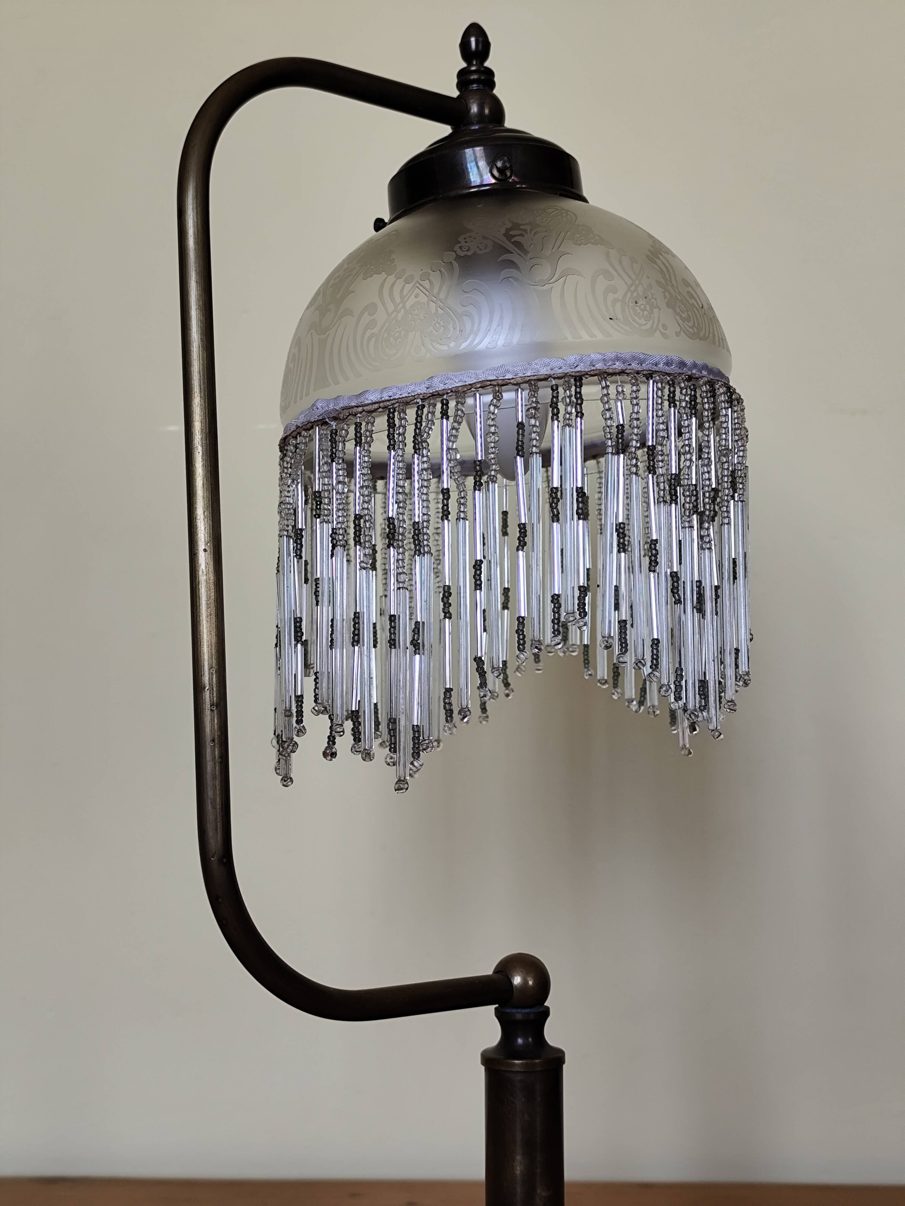 Retro brass lamp with a glass shade and bead fringes.