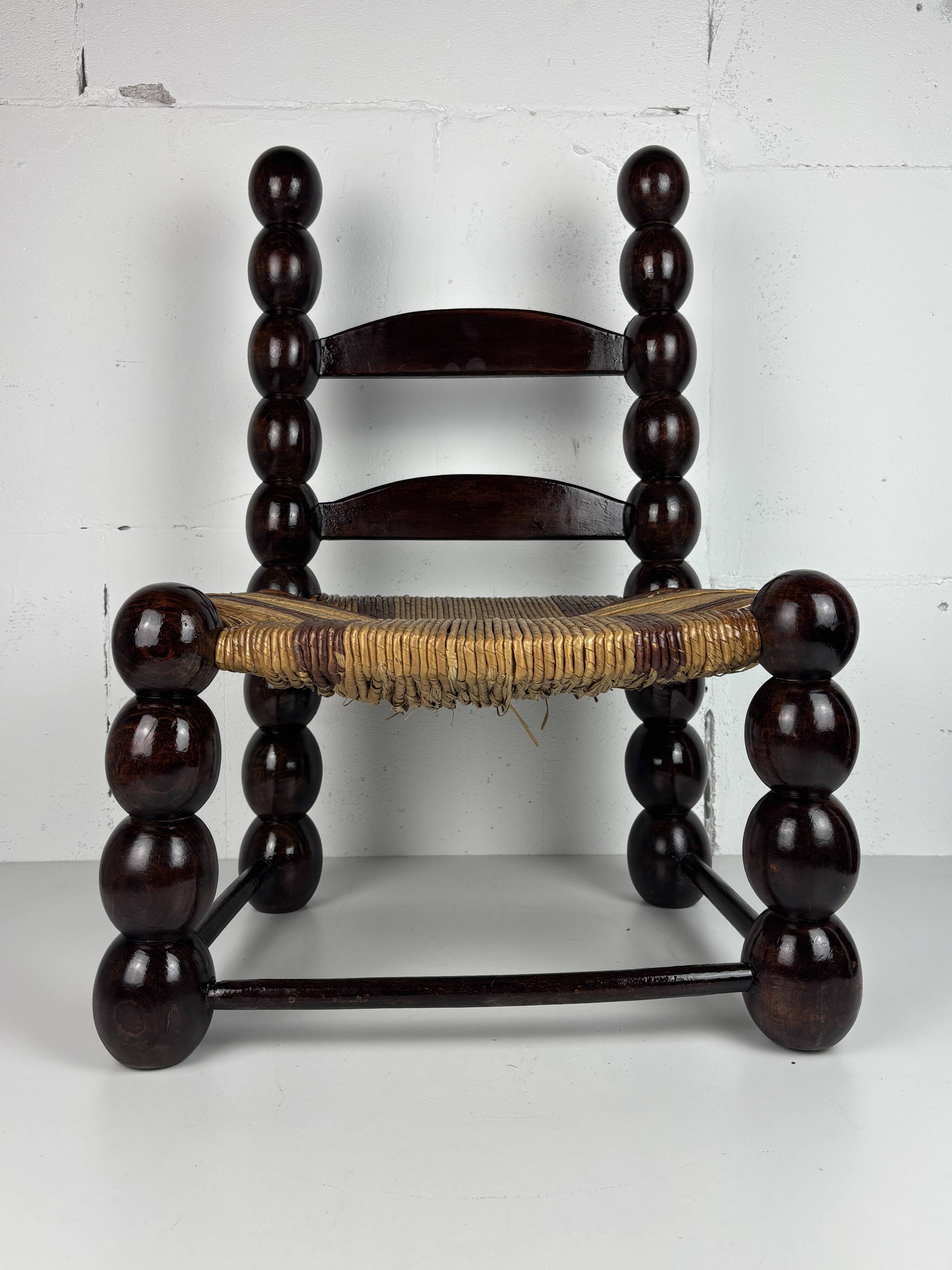 Brutalist wood turned bobbin low rush chair n the style of Charles Dudouyt