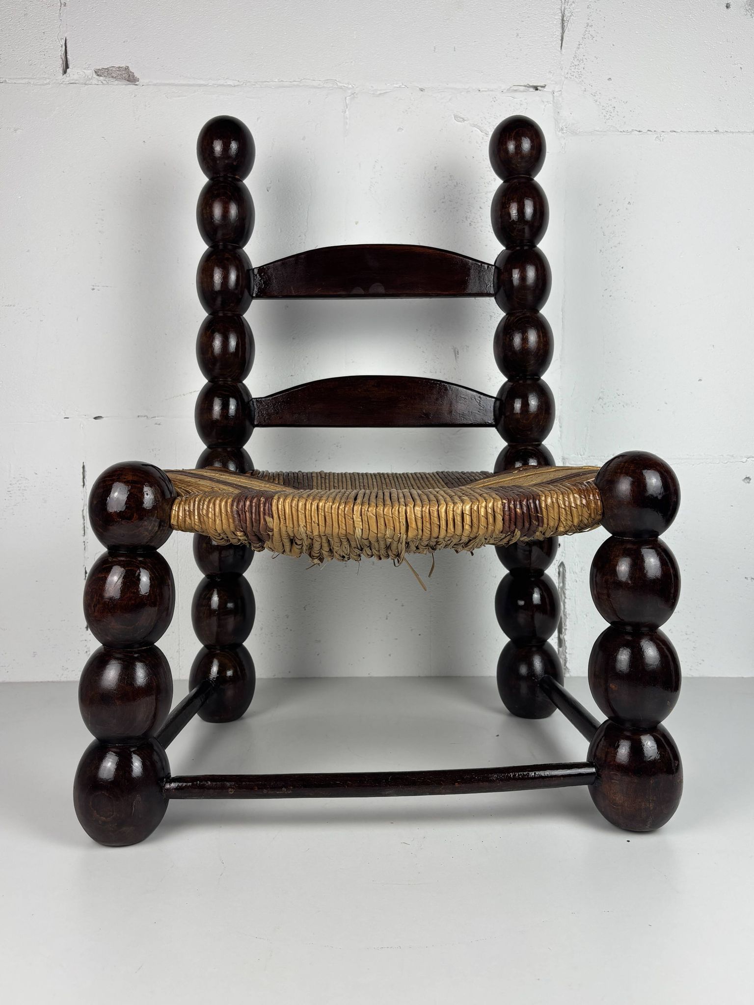 Brutalist wood turned bobbin low rush chair n the style of Charles Dudouyt