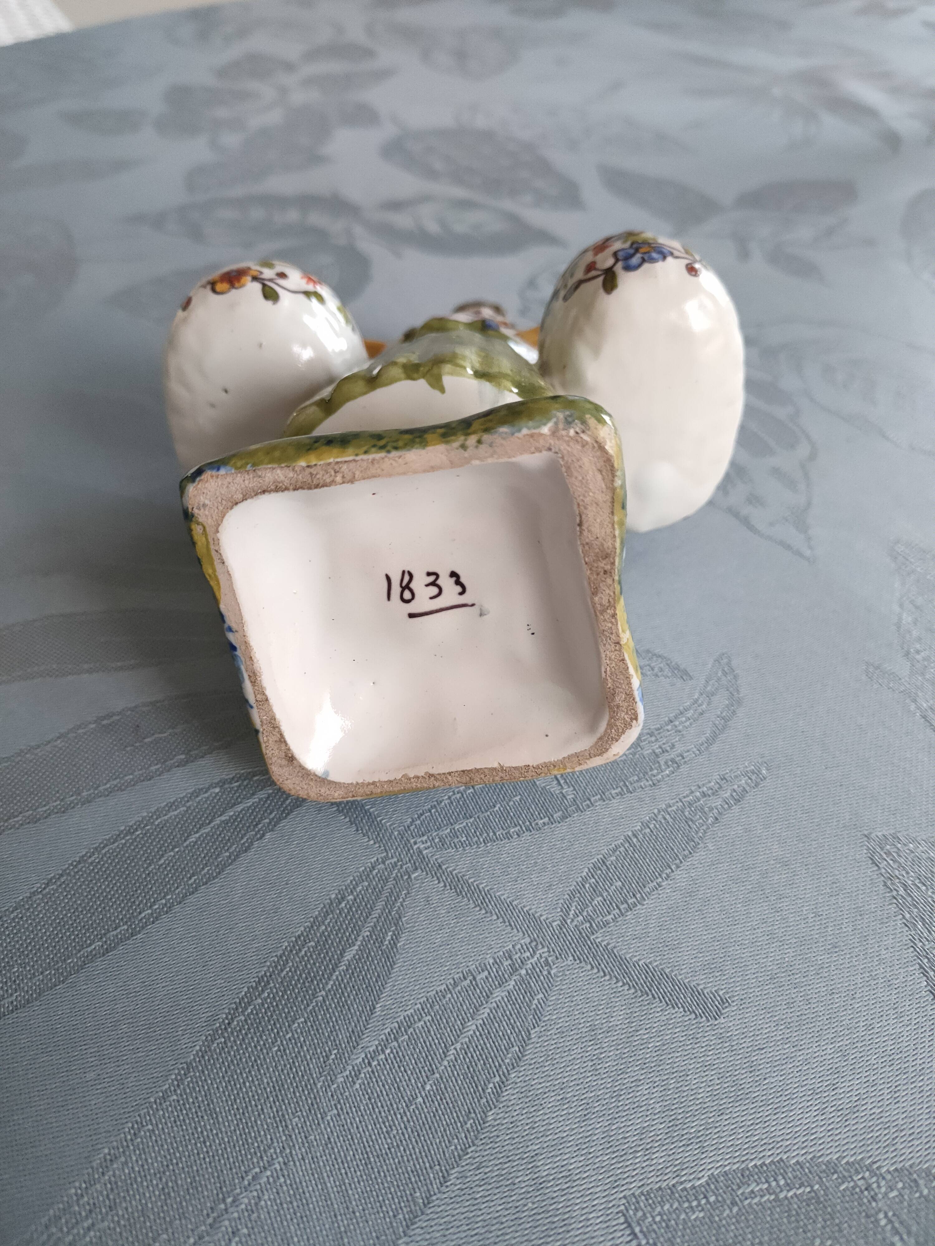 Antique earthenware salt cellar with a woman with baskets