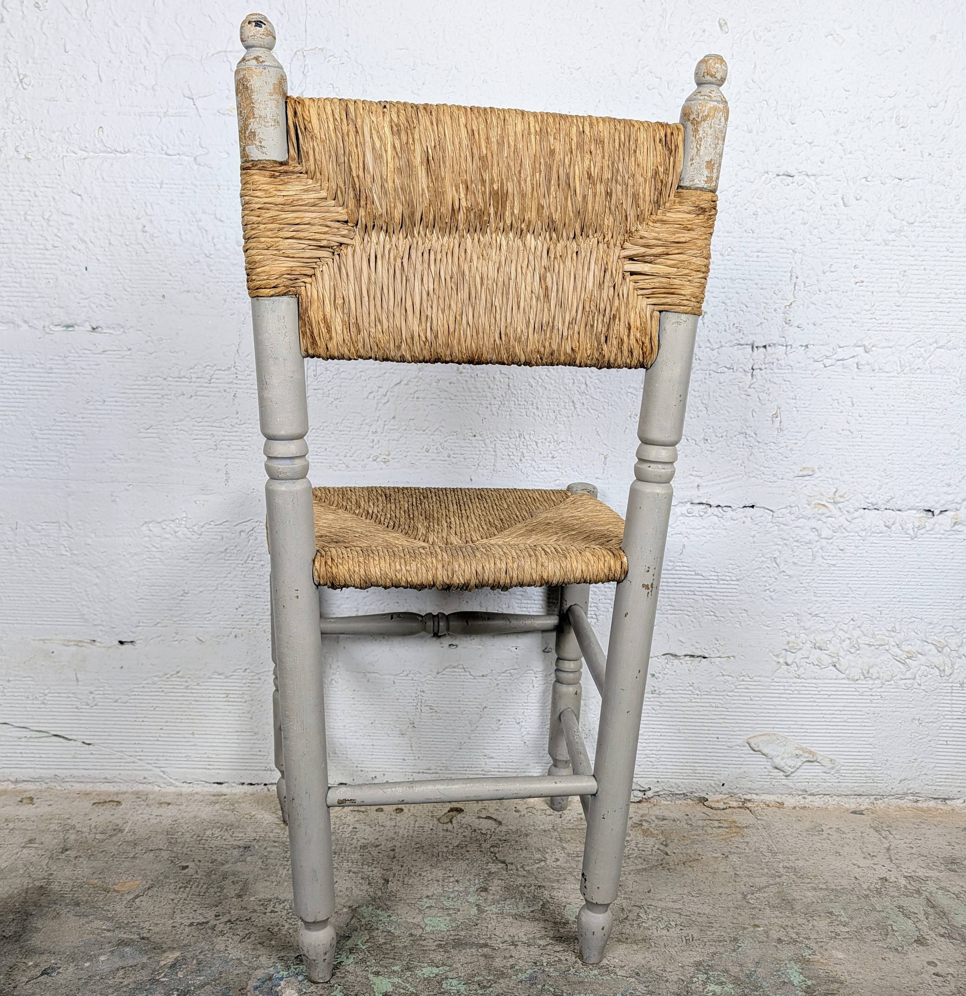 Rustic chair made of turned wood and straw.