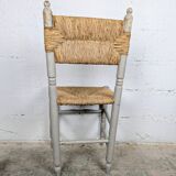 Rustic chair made of turned wood and straw.
