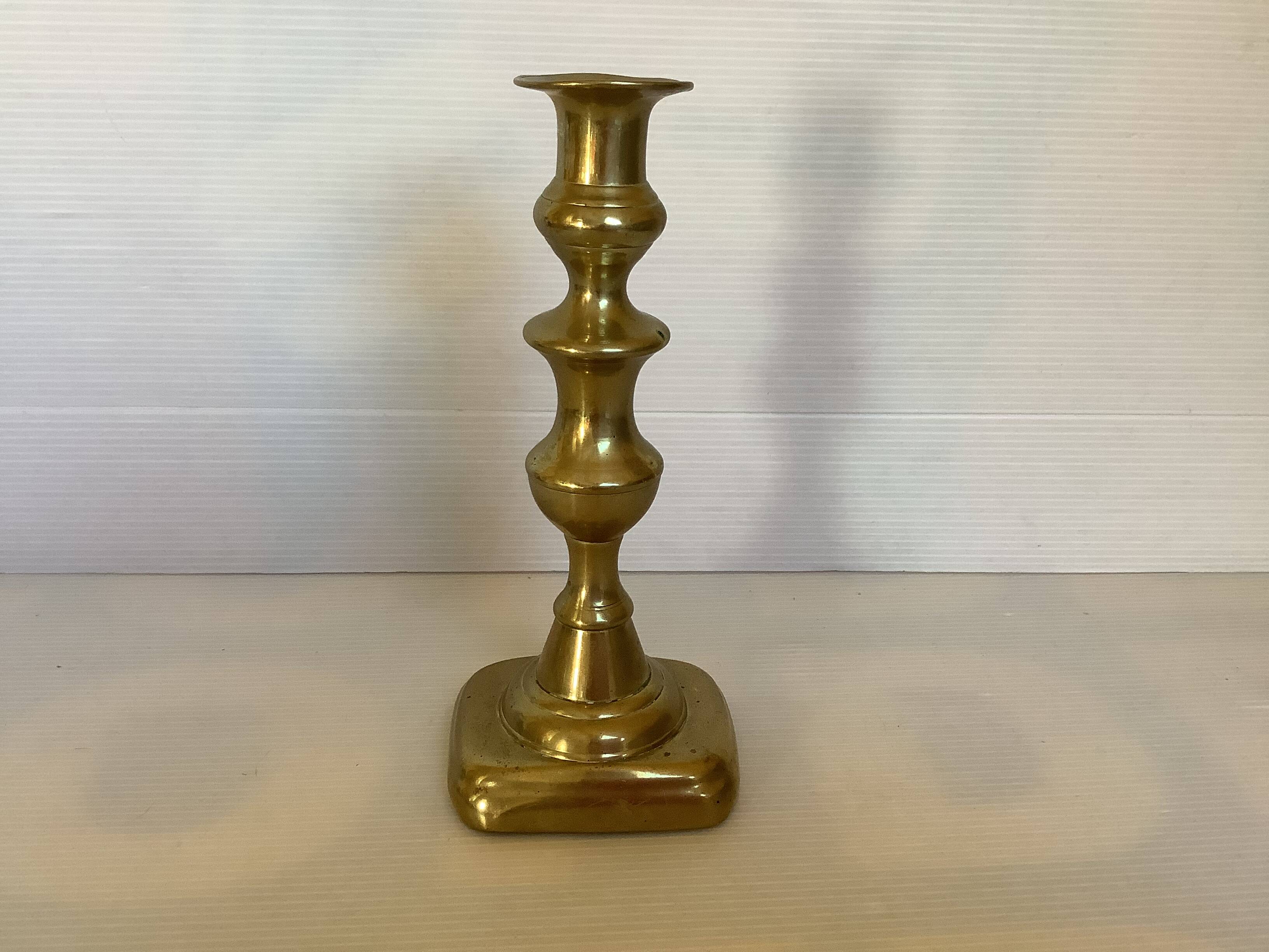 Brass candlestick with a rectangular base.