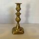 Brass candlestick with a rectangular base.
