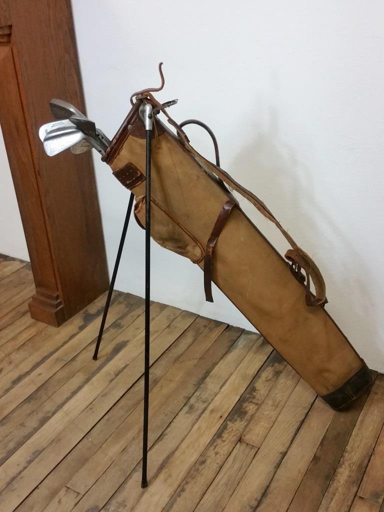 Old golf bag with 5 golf clubs