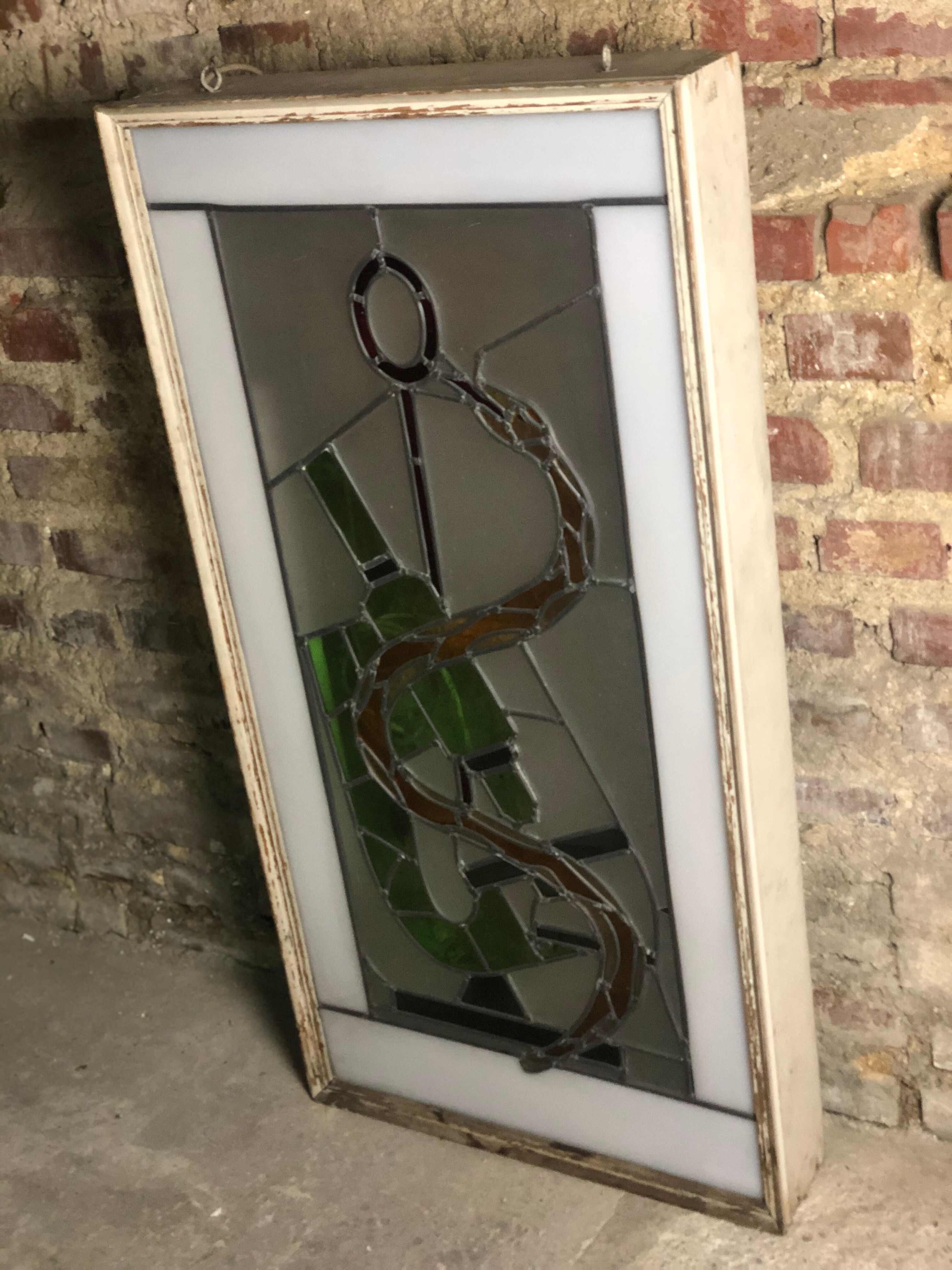 Old stained glass sign with deciduous decoration and microscope