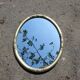 Miroir ovale fleurs sculptées doré