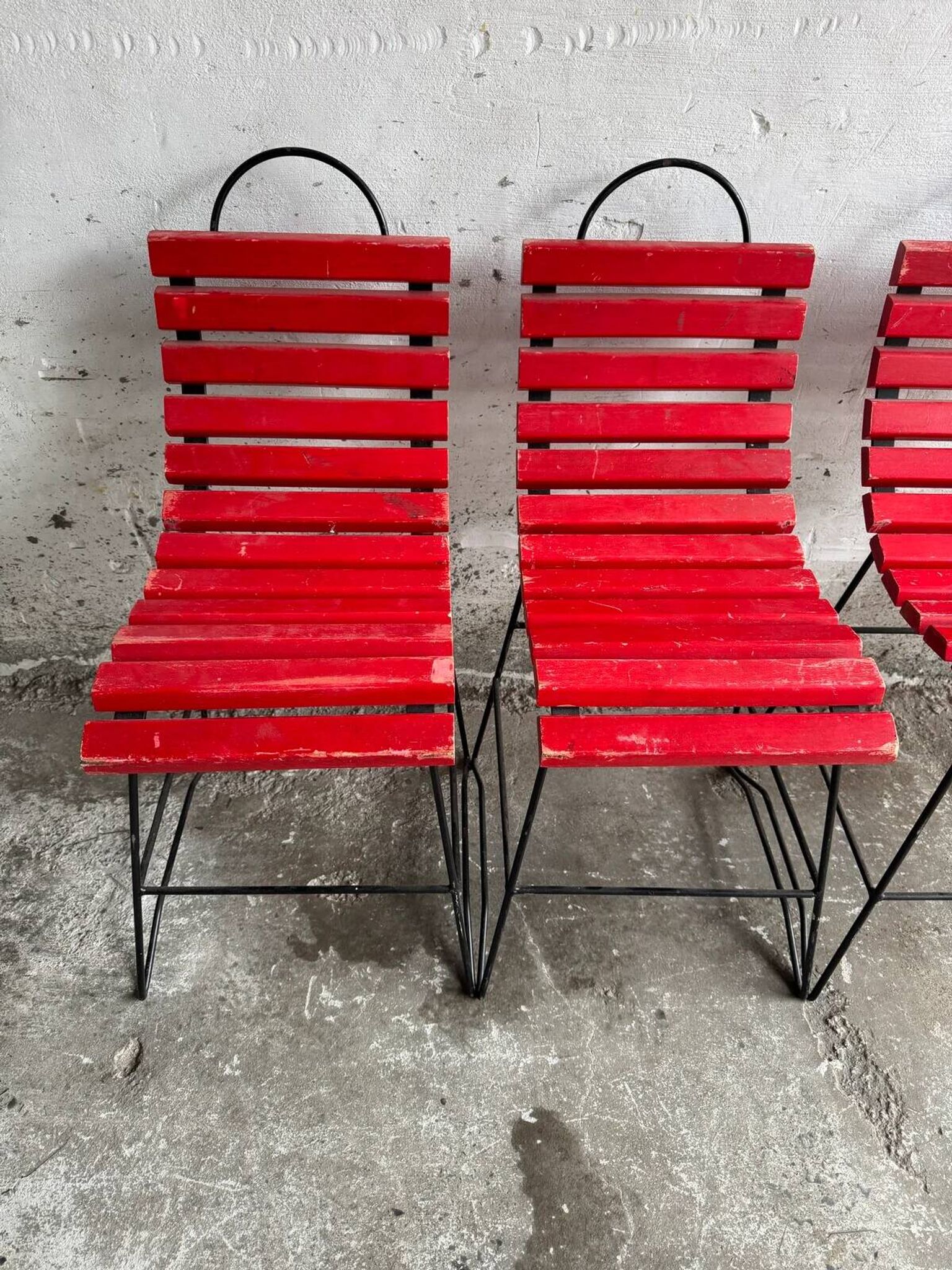 Red slatted chair with a black metal frame.