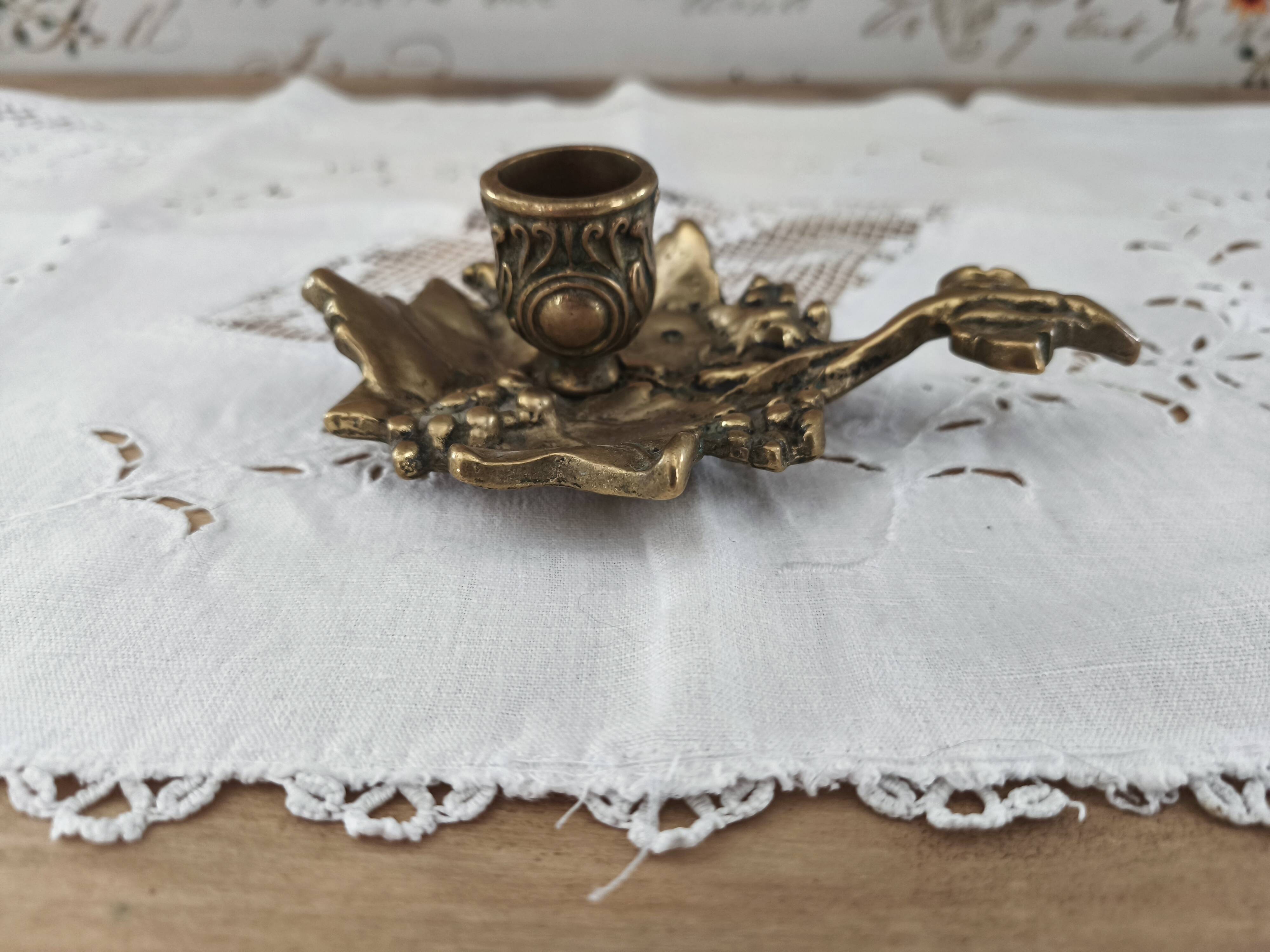 Hand-held candle holder called "cellar rat" in brass with vine leaf decoration