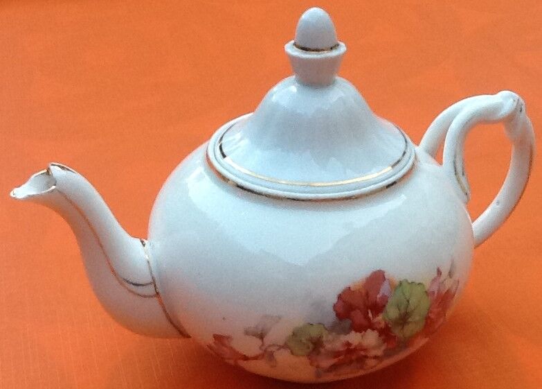 Old porcelain teapot with floral decoration