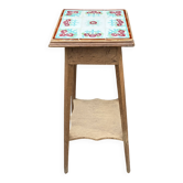 Antique wooden plant stand with ceramic tiles.