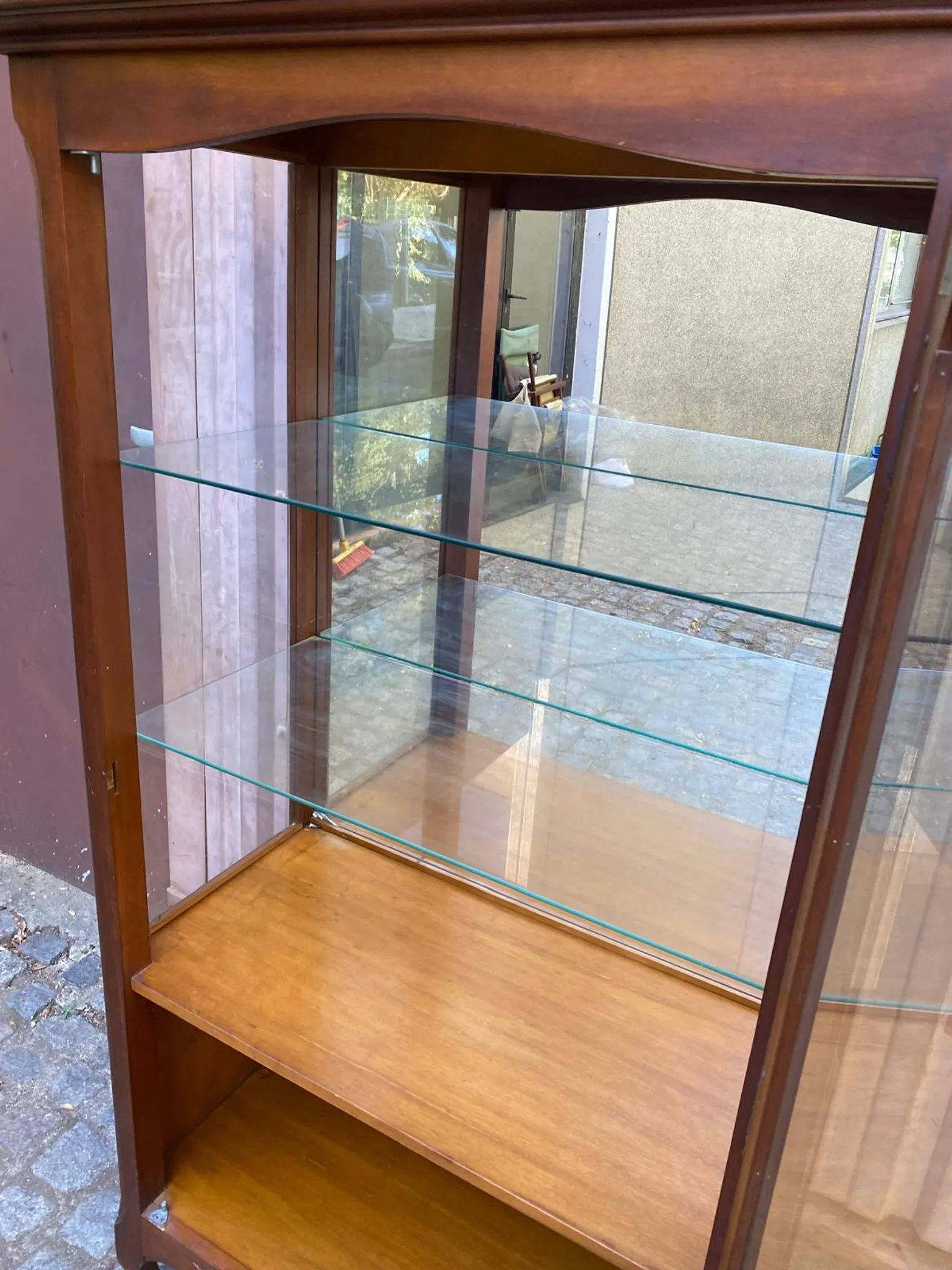 Louis XV style display cabinet in cherry wood with a mirrored back and glass shelves.