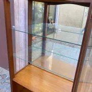 Louis XV style display cabinet in cherry wood with a mirrored back and glass shelves.