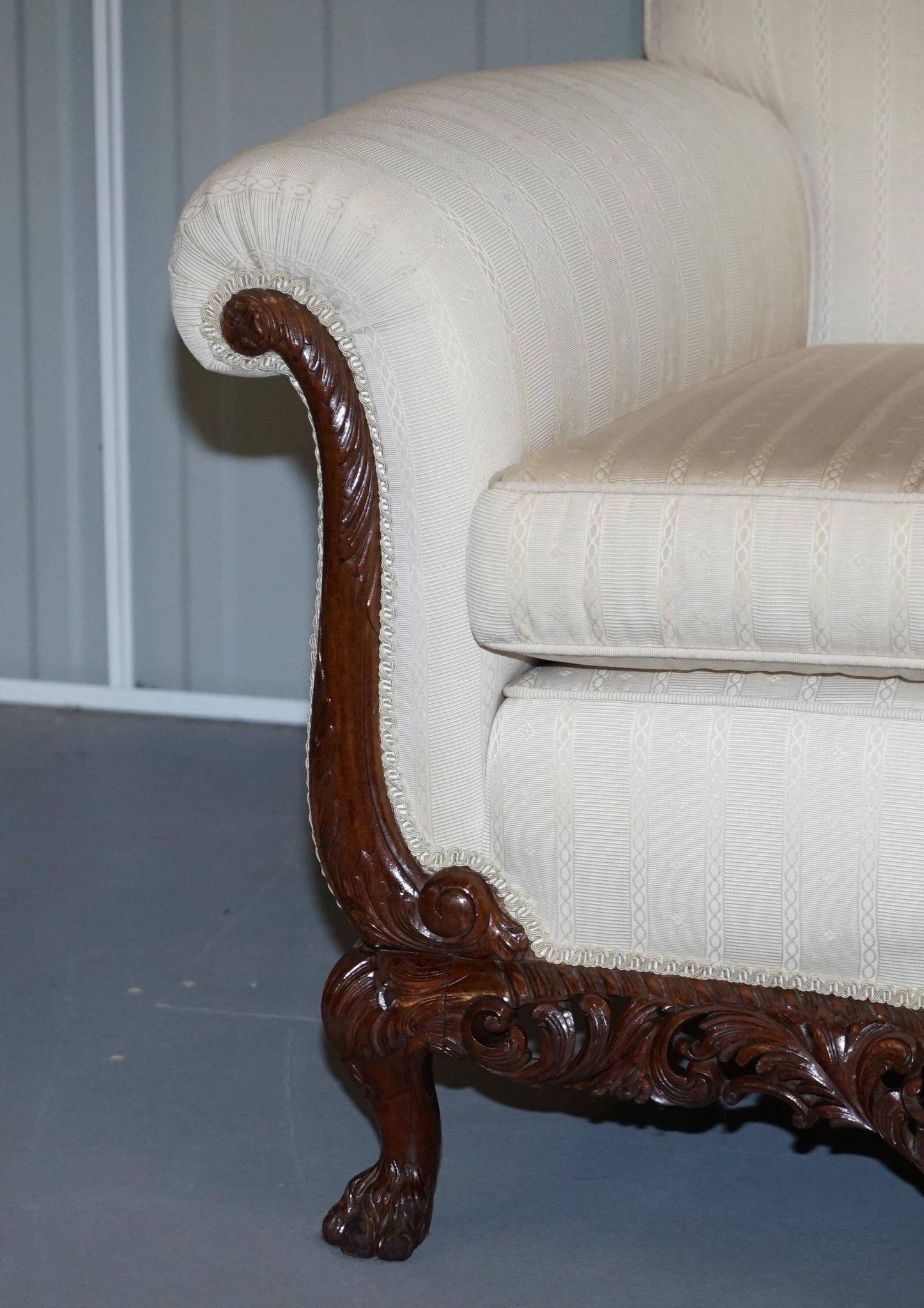 Three-seater canapé carved from solid walnut with claw feet.