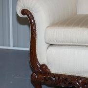 Three-seater canapé carved from solid walnut with claw feet.